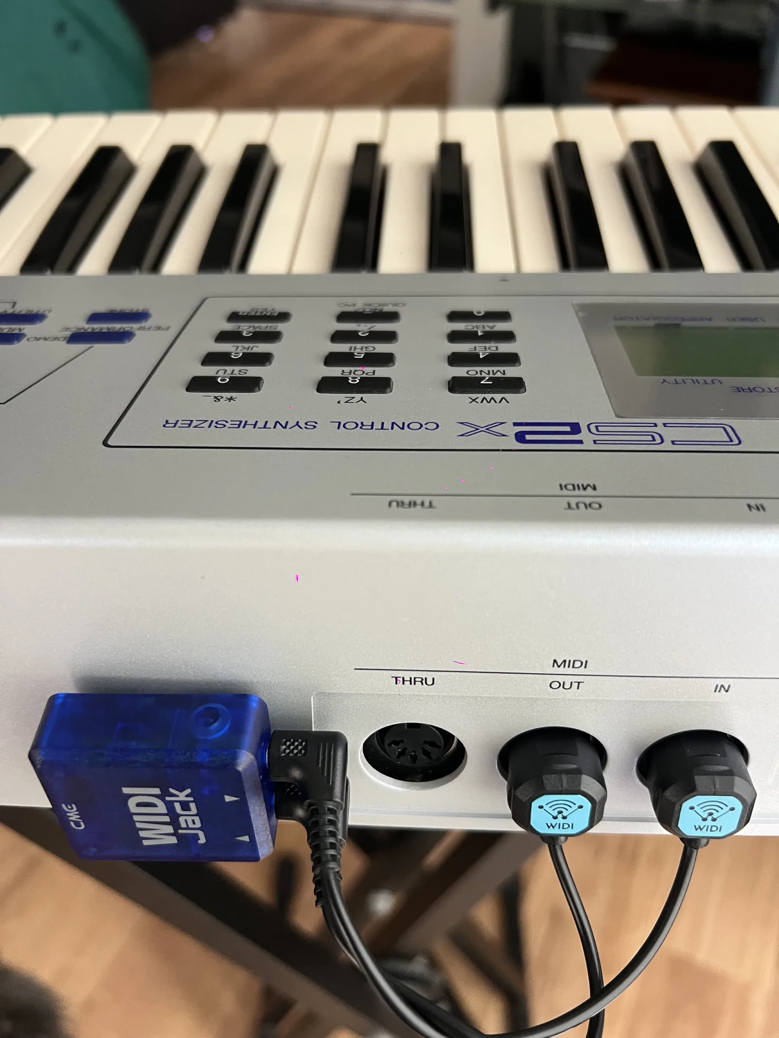 CME WIDI Jack connected to an older 61-key synthesizer keyboard using standard 5-pin MIDI connections